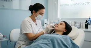 קוסמטיקאית מבצעת טיפול אלקטרוליזה להסרת שיער פנים (PCOS) במרפאה ישראלית מודרנית.